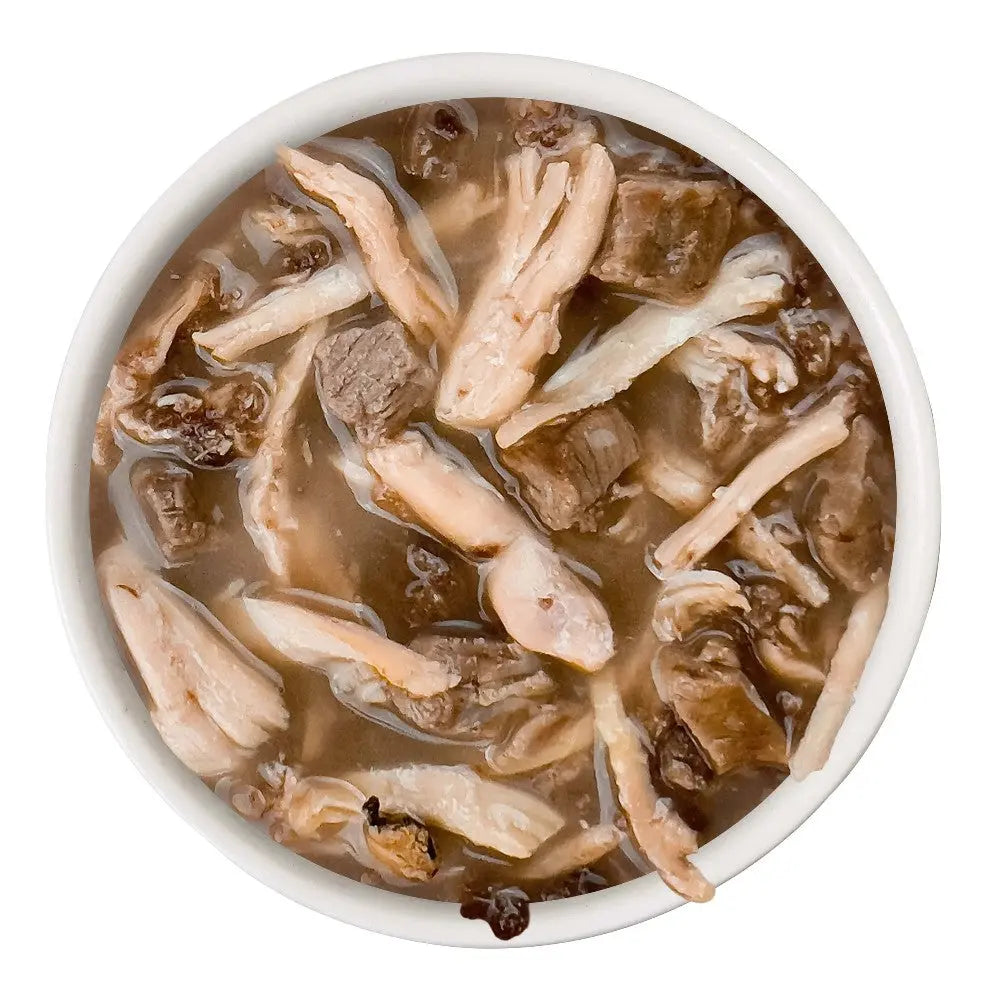 Bowl of savory meat stew with tender chicken and beef pieces in rich broth.