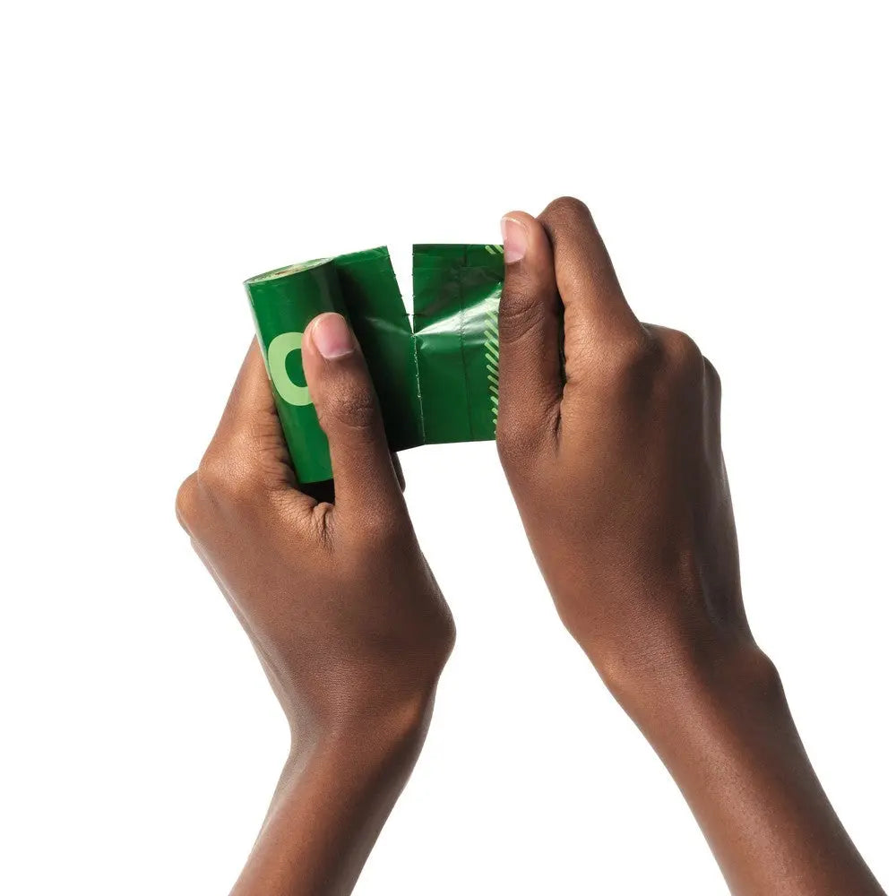 Hands tearing open a green food packaging bag for easy access to contents.
