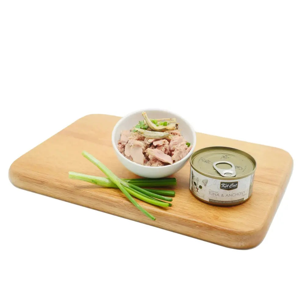 Canned tuna and anchovy cat food served in a bowl with green onions on a wooden cutting board.