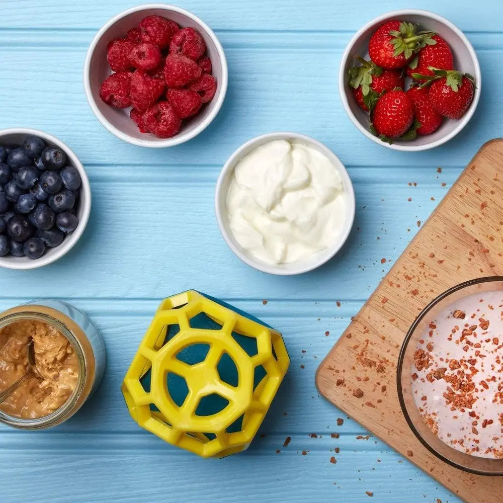 Colorful bowls of fresh berries, yogurt, and peanut butter on a blue wooden surface.