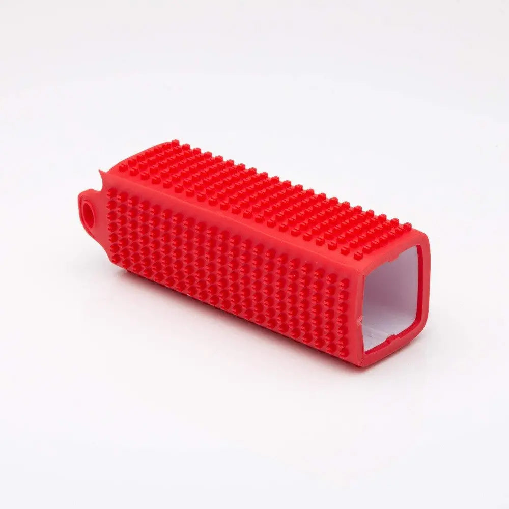 Red silicone pet grooming tool with textured surface for effective brushing and de-shedding.