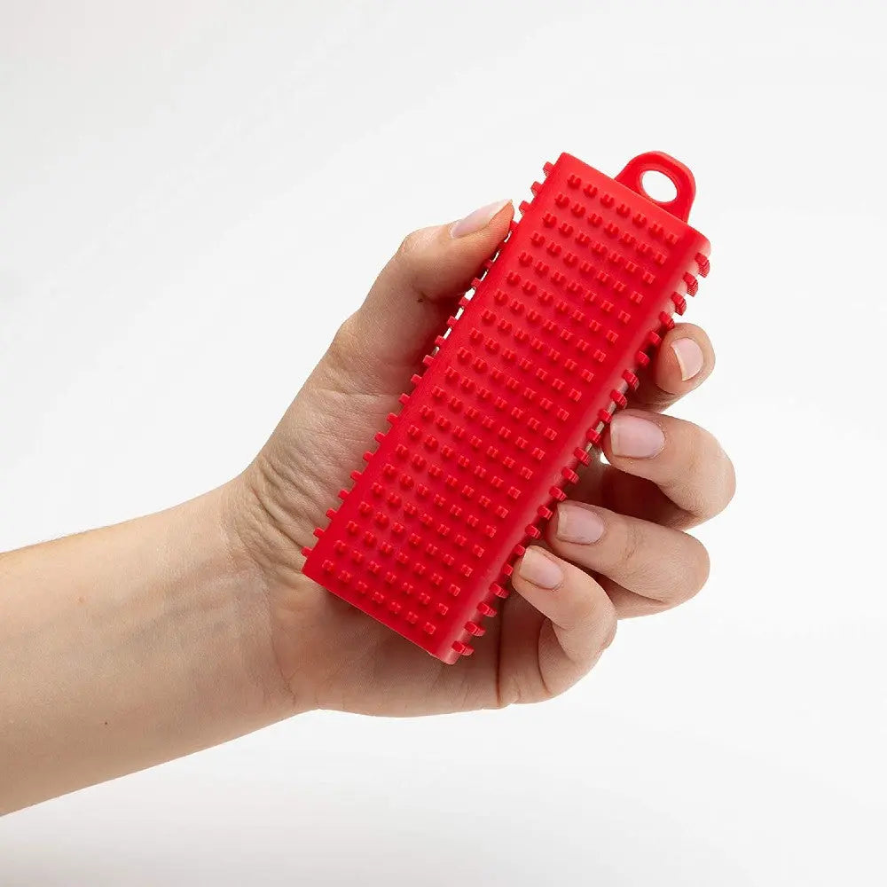 Red silicone pet grooming brush for effective shedding and cleaning.