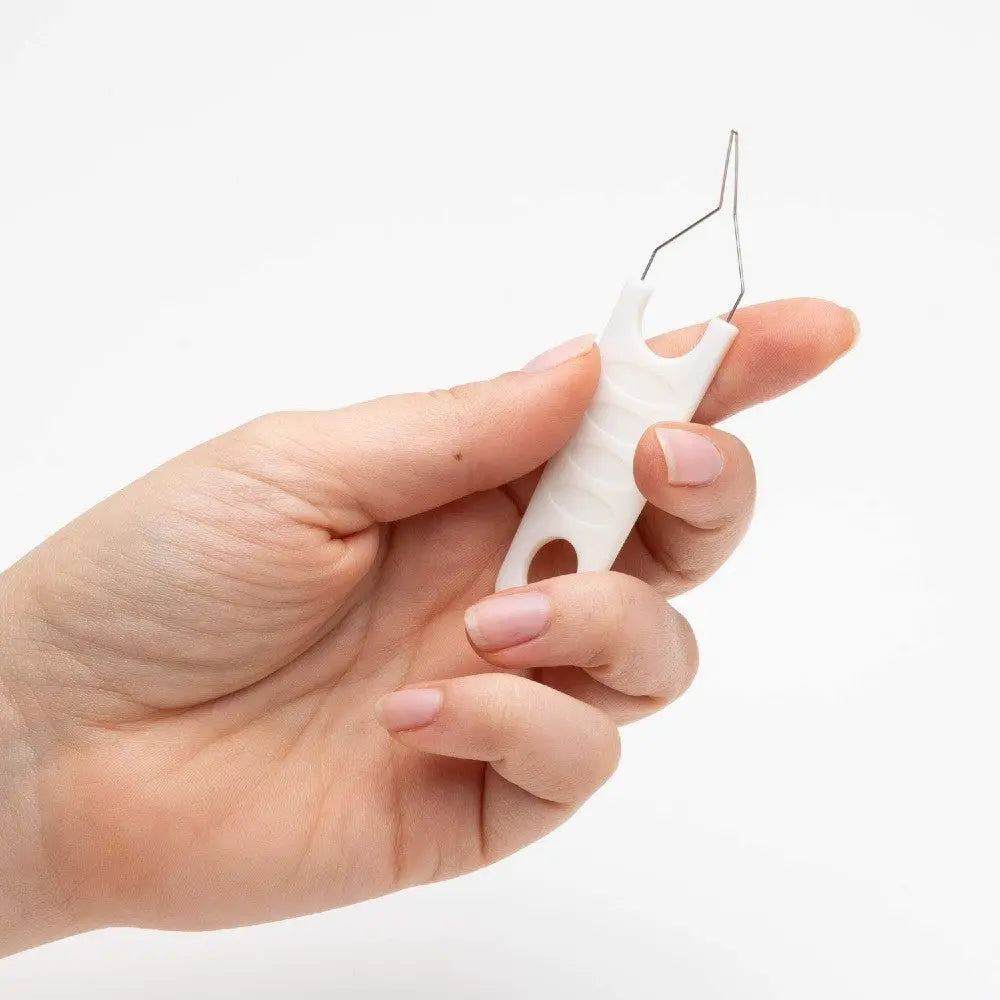 Hand holding a dental floss pick for effective oral hygiene and plaque removal.