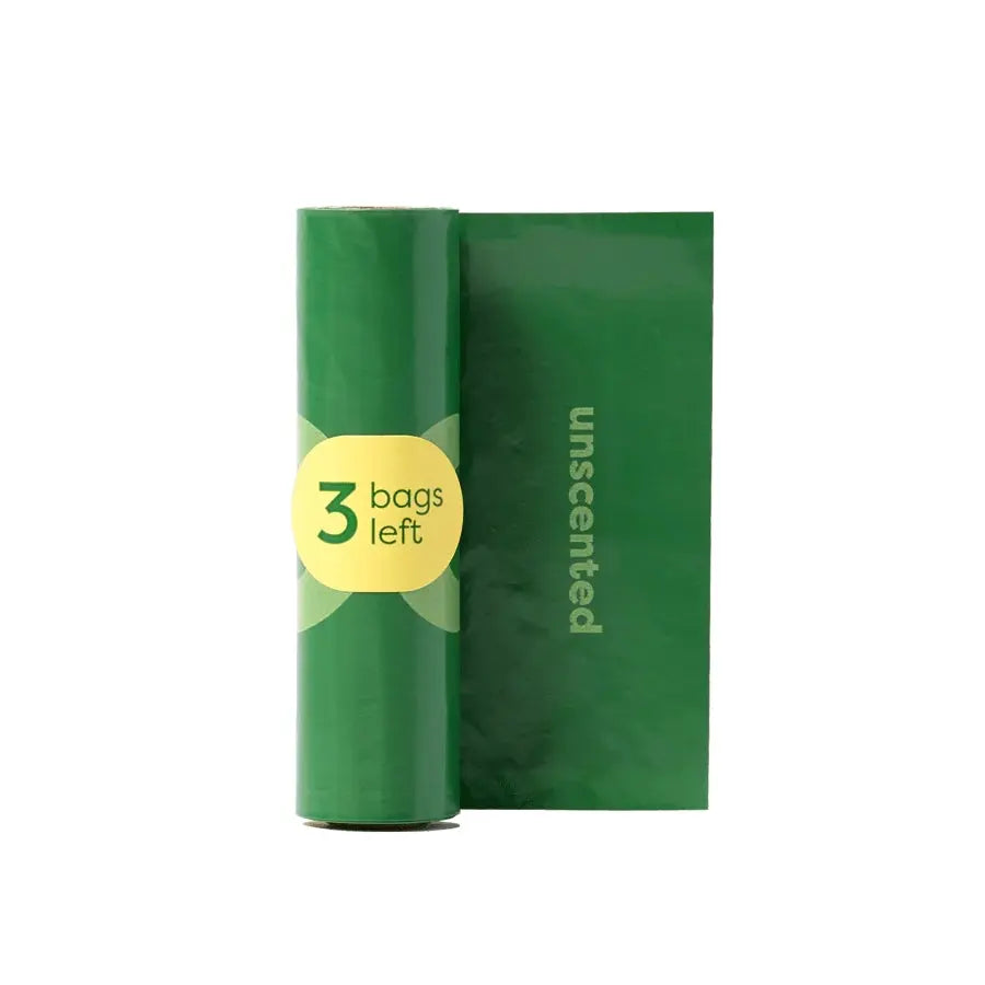 Unscented green trash bags roll with three bags remaining for eco-friendly waste disposal.
