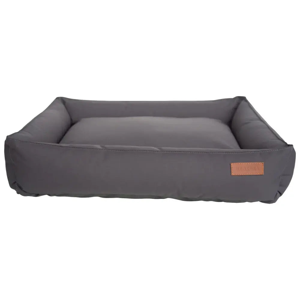 Cozy gray pet bed with soft padding and stylish leather label for ultimate comfort.