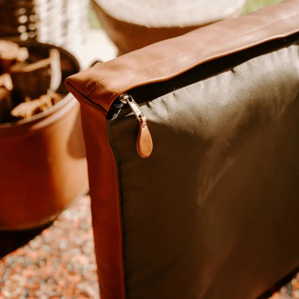 Stylish outdoor cushion with a leather zipper, perfect for patio decor and comfort.