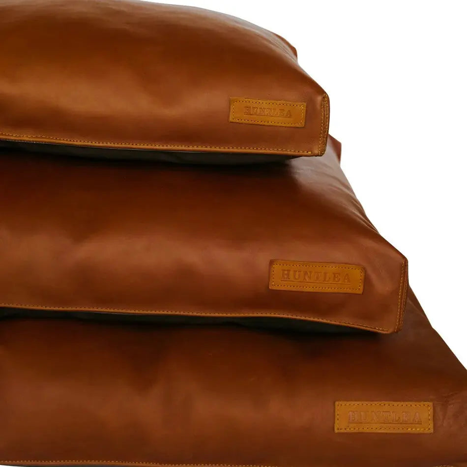 Stylish brown leather dog beds stacked for comfort and durability in any home decor.