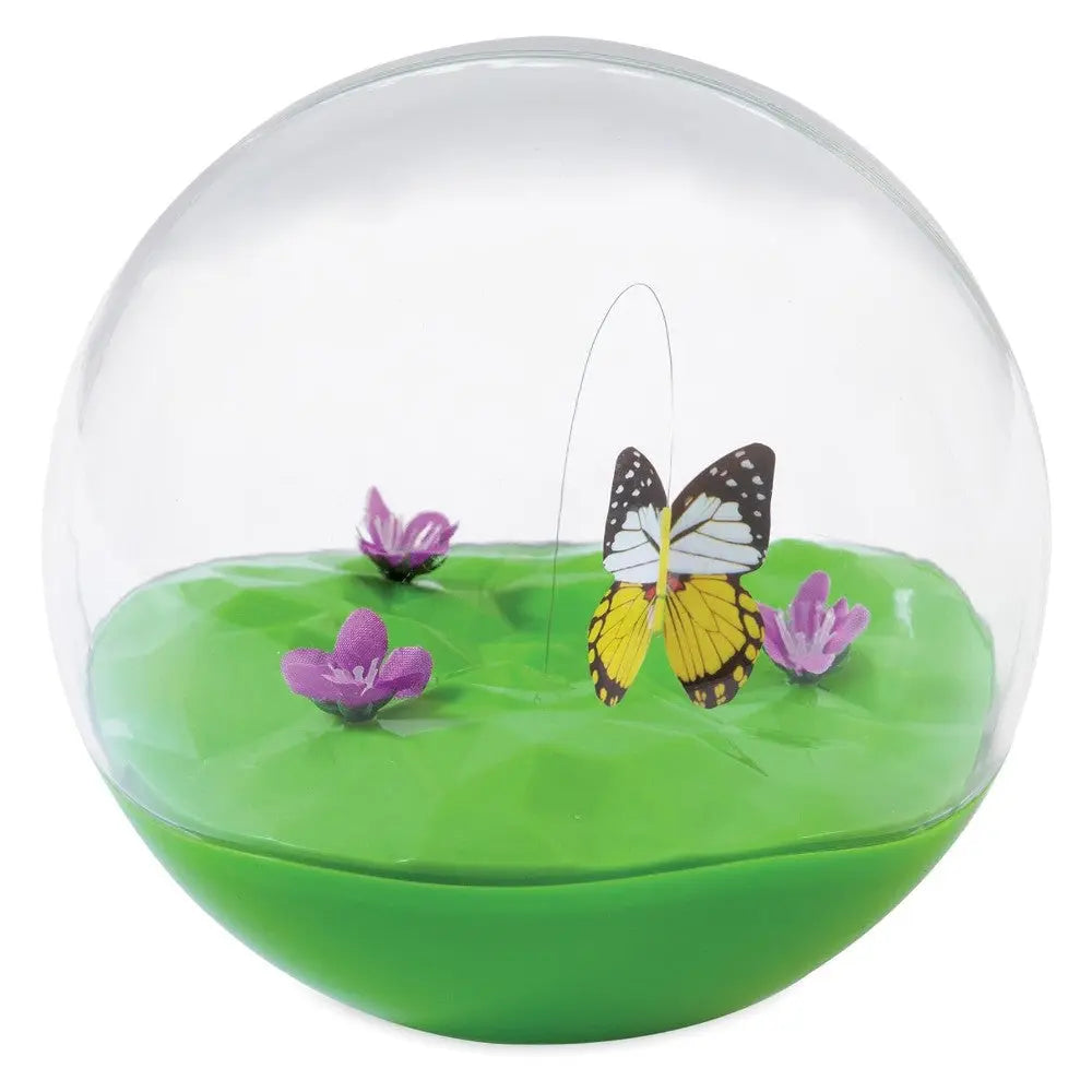 Decorative glass dome with a butterfly and colorful flowers on a green base.