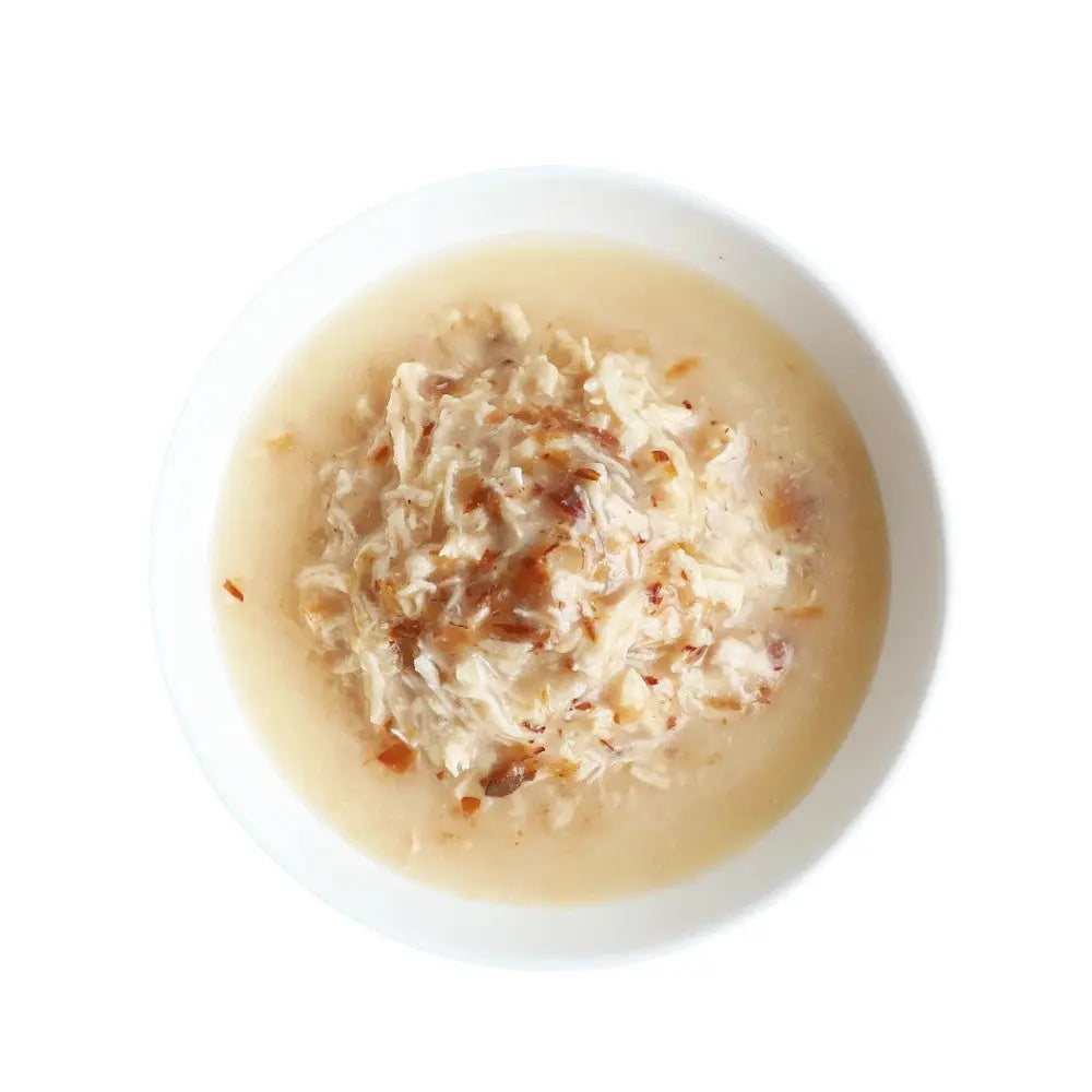 Bowl of creamy chicken soup with shredded meat and a savory broth.