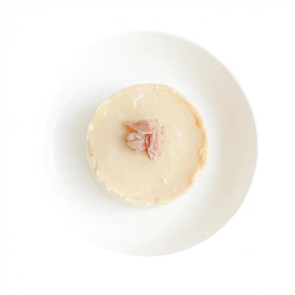 Creamy pet food served in a white bowl, topped with shredded meat for added flavor.