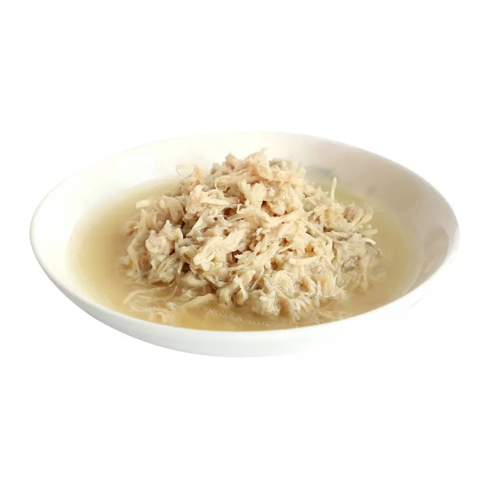 Shredded chicken in broth served in a white bowl, perfect for soups or meal prep.
