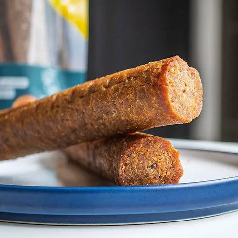 Plant-based protein sticks on a blue plate, showcasing healthy snack options for active lifestyles.