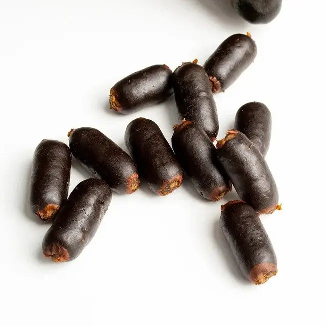 Dark chocolate-covered snacks arranged on a white background, perfect for a sweet treat.