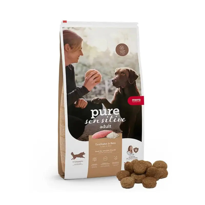 Dog food bag featuring pure sensitive formula for adult dogs, with a woman feeding a dog.