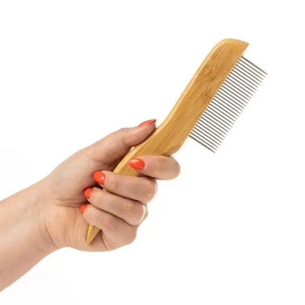 Bamboo hair comb held in a hand, showcasing eco-friendly grooming essentials.