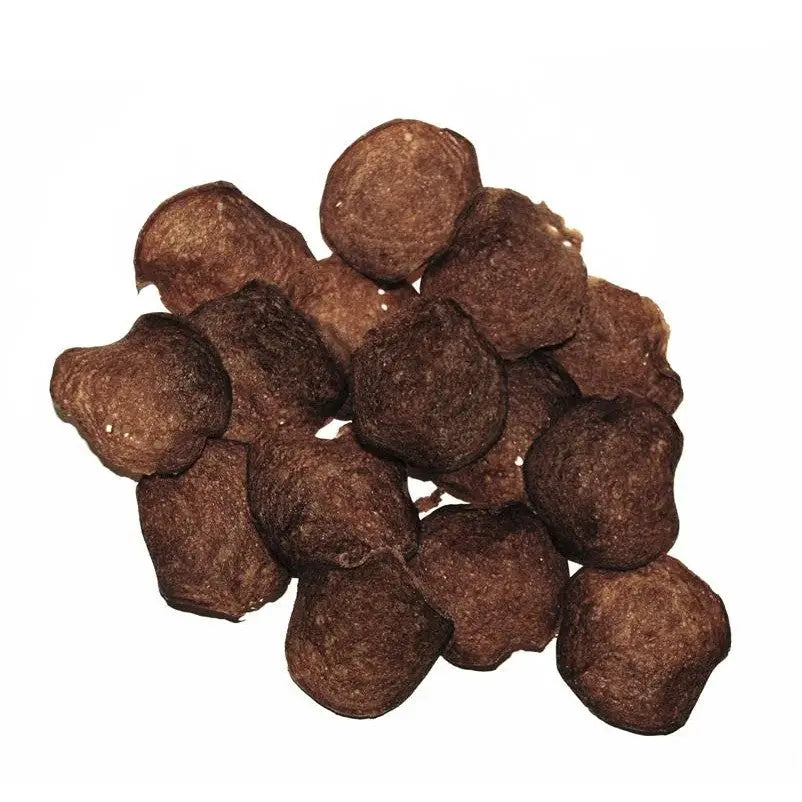 Brown pet food kibble pieces scattered on a white background, showcasing their round shape and texture.
