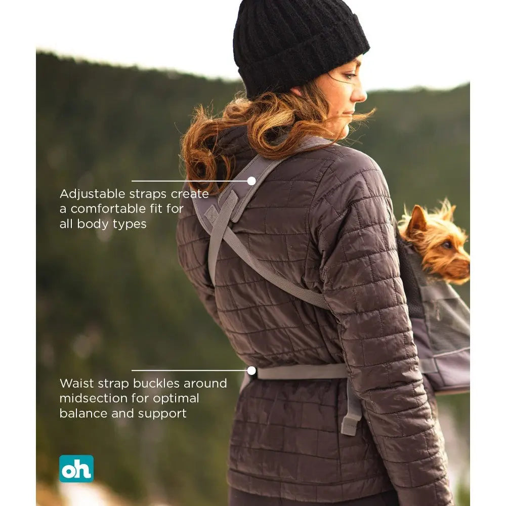 Woman wearing a pet carrier with adjustable straps for comfort and support while outdoors.