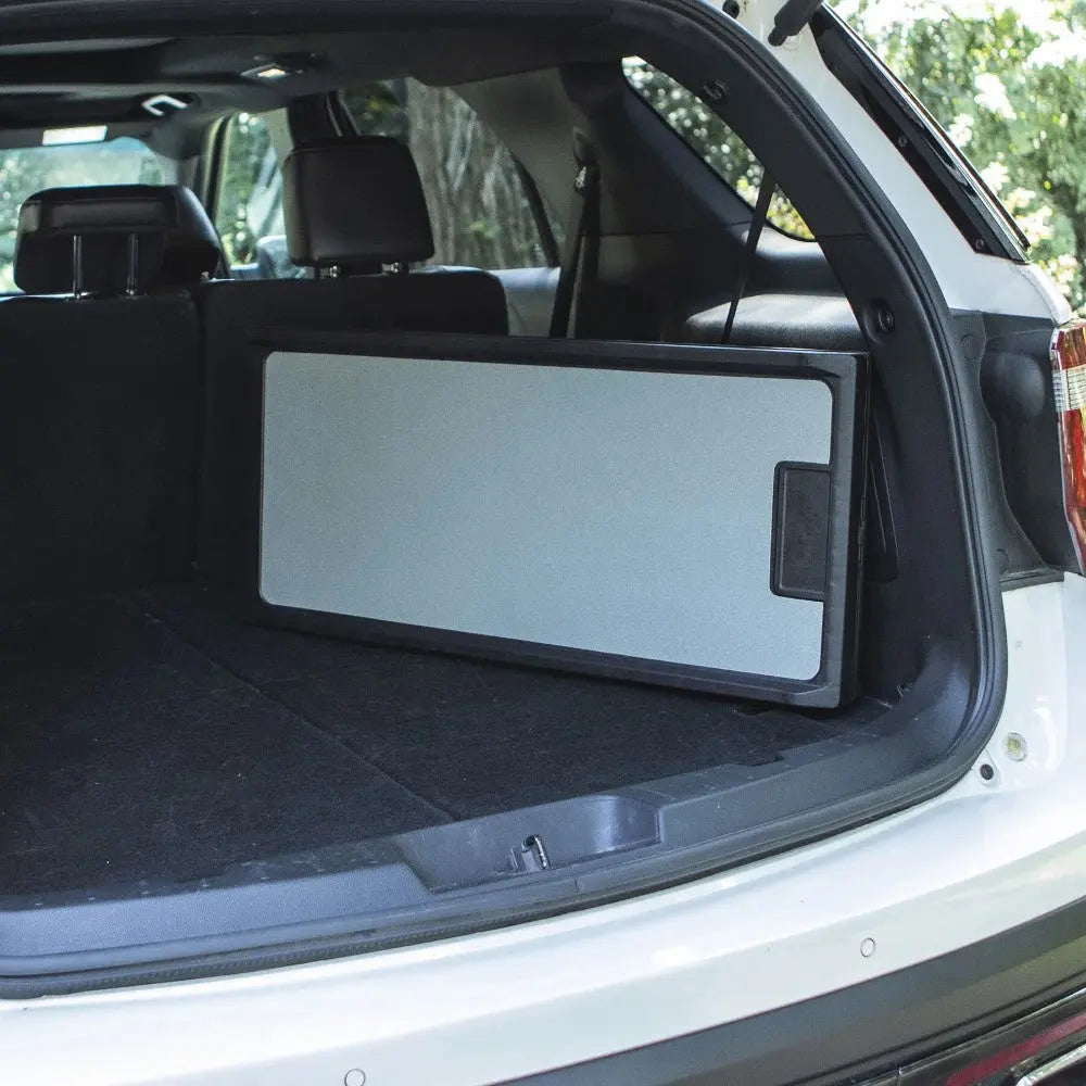 Compact folding table stored in the trunk of an SUV, ideal for outdoor activities and picnics.