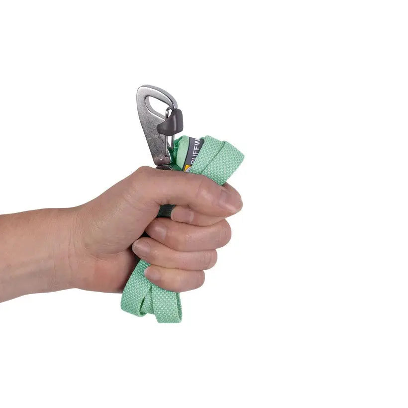 Hand holding a green climbing rope with a carabiner, showcasing outdoor gear for climbing enthusiasts.