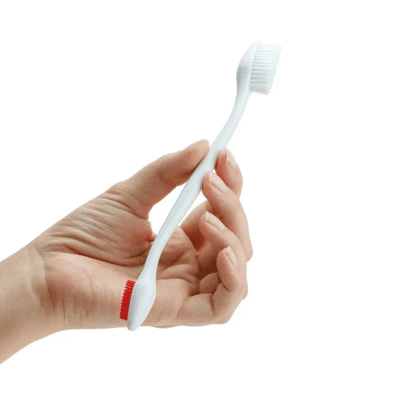 Hand holding a white toothbrush with a red accent, ideal for daily dental care.