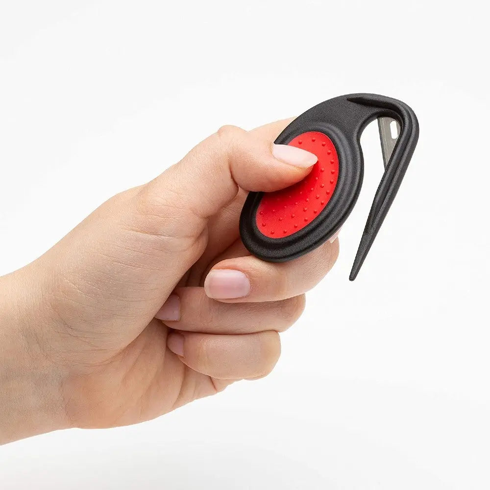 Hand holding a black and red ergonomic tool for easy gripping and handling.