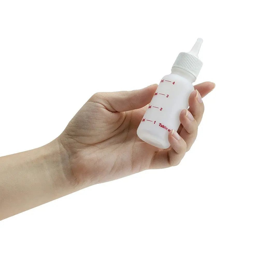 Hand holding a small plastic squeeze bottle with measurement markings for precise dispensing.