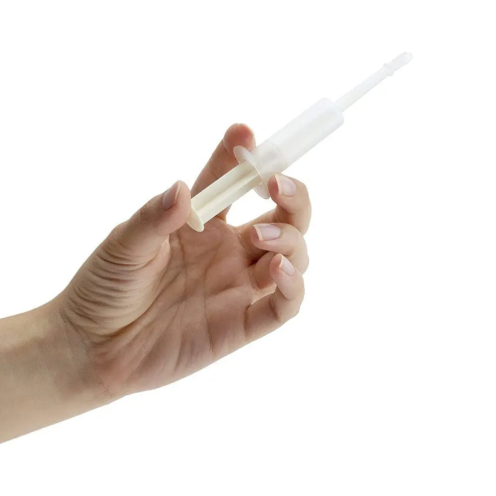 Hand holding a clear plastic syringe for precise liquid measurement and dispensing.