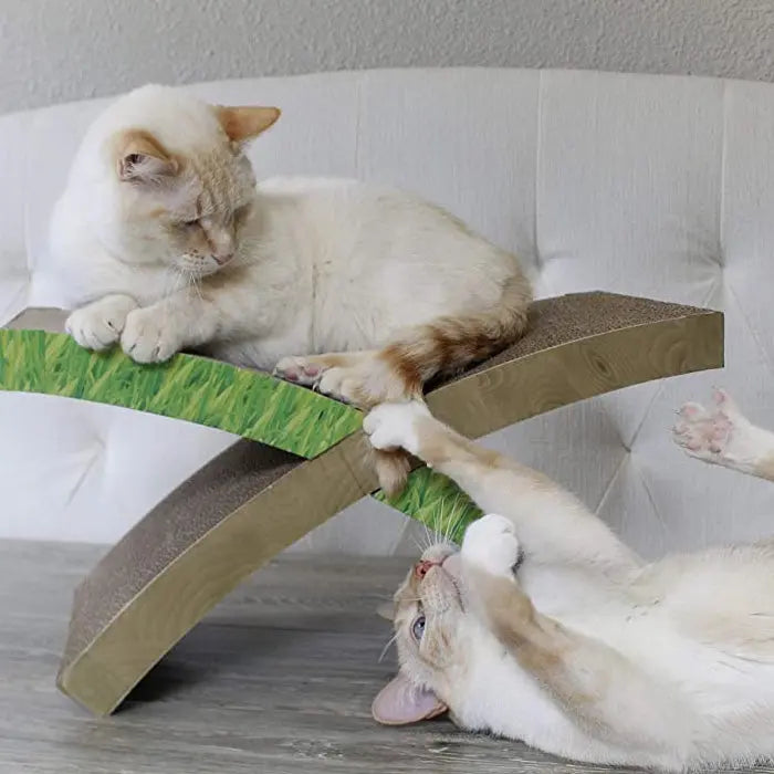Two playful cats on a unique grass-themed scratching post, enjoying their time together.
