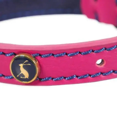 Pink leather bracelet with blue stitching and a gold logo accent.