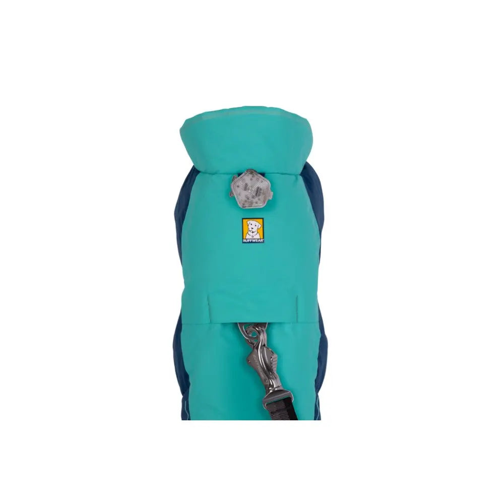 Dog backpack in teal and navy, featuring a secure clip and adjustable straps for outdoor adventures.