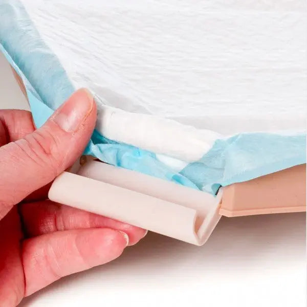 Hand holding a pet training pad with a roll-up feature for easy disposal and clean-up.