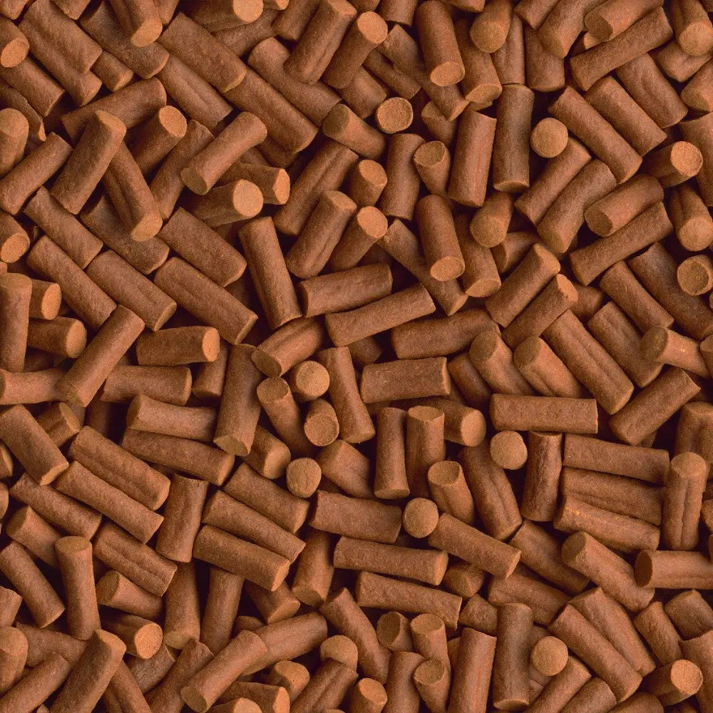 Brown pet food pellets scattered on a surface, showcasing their texture and shape for easy feeding.