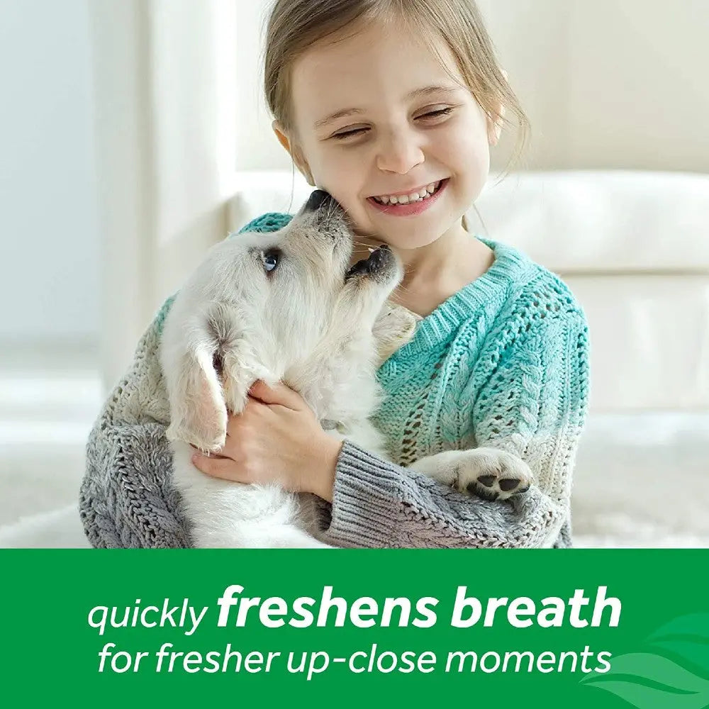 Girl cuddling a puppy, showcasing a joyful moment and fresh breath benefits.